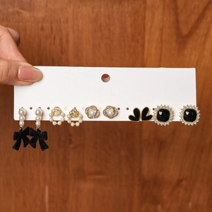 Detail of 6-pair earring set featuring black flocking bows and pearl heart accents
