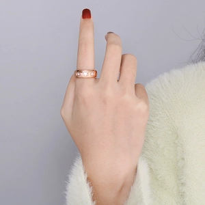 Anello a cuore in oro rosa con diamanti indossato sul dito medio di una modella
