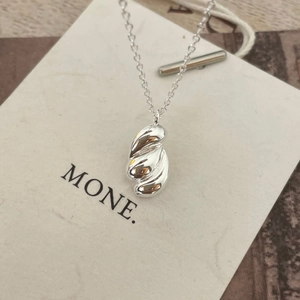 Detail shot of irregular wavy 925 sterling silver waterdrop pendant on a delicate chain