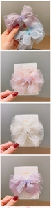 Close-up of handmade chiffon bow hair clips with pearls and small butterflies in pastel colors