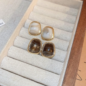 Vintage geometric trapezoid resin stud earrings with gold metal edges on jewelry tray