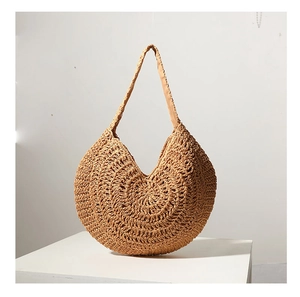 Detailed view of natural straw woven texture on a large capacity shoulder beach bag