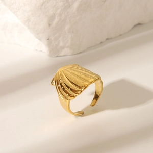 Macro detail of golden irregular open ring with fan-shaped shell texture on stone