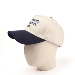 Detail of embroidered 'on my husband's tab' text on a two-tone cotton baseball cap