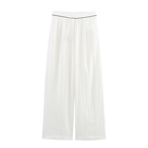 Detail of high-waisted white wide-leg trousers with elegant black piped trim at the waist