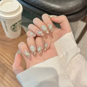 Handmade mint green press-on nails with gold edges and shell accents for women