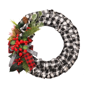 Christmas wreath with black-white plaid fabric, red berries, pine cones and bows