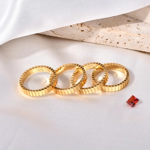 Set of four gold-plated stainless steel gear rings with vertical textured grooves