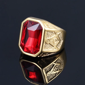 Detailed view of golden Masonic ring with red ruby gemstone and engraved square and compass