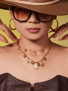 Detail of layered owl pendant necklace with 5A zircon and heart charms on gold plating