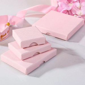 Pink cross-textured jewelry gift boxes in four sizes on a white marble background