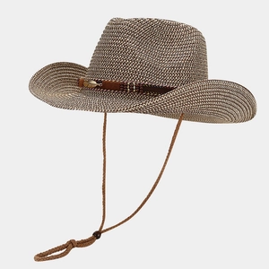Detailed close-up of woven cowboy straw hat featuring metal feather ornament and chin cord