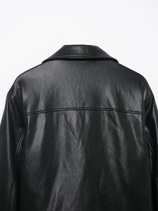 Close-up of the pebbled leather texture and stitching on the back of a black biker jacket