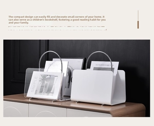 Close-up of modern acrylic and metal magazine rack with curved handles for desktop storage