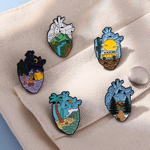 Set of five creative heart-shaped landscape enamel pins on white canvas background