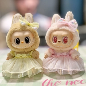 Detail of cute plush doll outfits in yellow and pink lace dresses with matching headbands