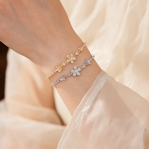 Vista dettagliata di eleganti bracciali a fiori in oro e argento con zirconi lucenti