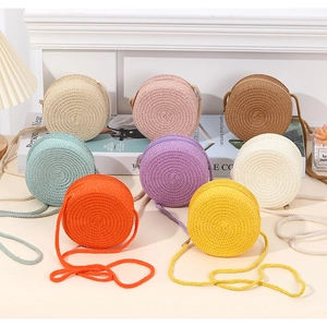 Detailed view of handmade mini round straw crossbody bags in eight vibrant summer colors