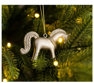 Silver horse ornament with glittery finish hanging on a Christmas tree with warm lights