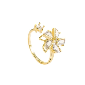 Rotating gold windmill ring with sparkling zircon flower petals on white background