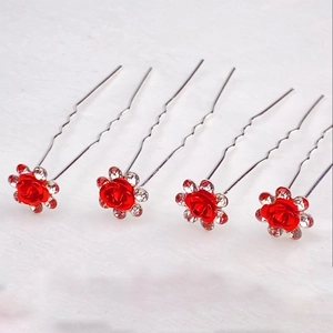 Dettaglio di forcine per capelli argentate con rose rosse e strass scintillanti