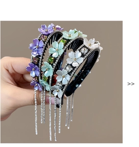 Detailed view of rhinestone flower hair clips with tassels in purple, green, and white