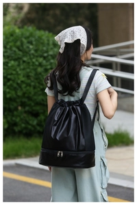 Detail of black waterproof drawstring gym bag showing bottom zipper shoe compartment