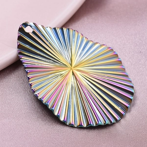 Détail d'un pendentif goutte arc-en-ciel avec des nervures sur tissu rose