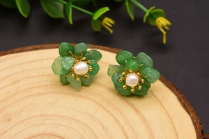 Detailed macro shot of green mineral stone flower earrings with a white pearl center