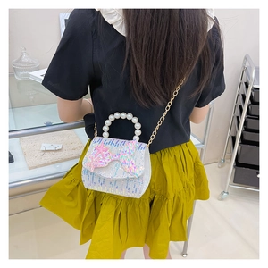 Detail of sequin kids bag featuring a pearl handle and mermaid tail embellishment