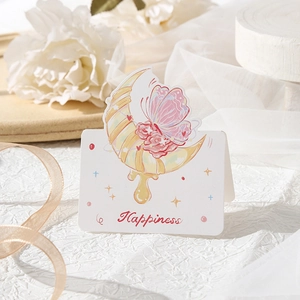 Detail of folding flower card with moon and rose patterns on a soft white tulle background