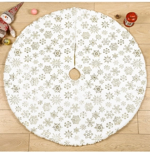Detail of white plush Christmas tree skirt with golden foil snowflake patterns