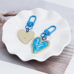 Detail view of heart-shaped evil eye keychains in a ceramic dish on a magazine