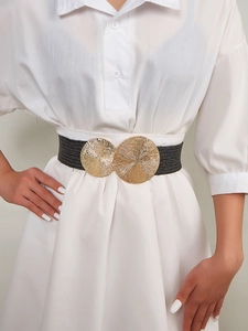 Detail of a black woven elastic belt with a large gold round buckle on a white dress