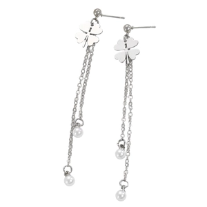 Detailed close-up of clover earrings with long silver tassels and white pearls