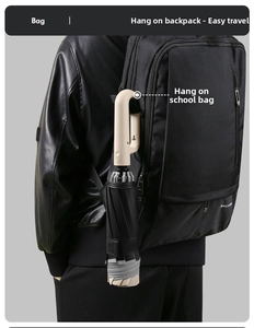 Detail of a portable folding umbrella with a unique U-shaped hook handle hanging on a bag