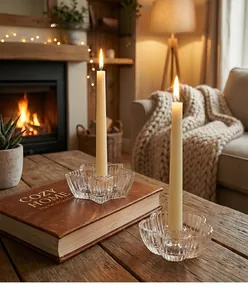 Detailaufnahme klarer Glas-Kerzenhalter in Stern- und Blumenform auf einem Tisch