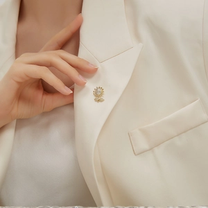 Close-up of a sparkling gold sunflower brooch with micro-paved diamonds on a suit lapel