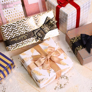 Elegant gold foil gift wrapping paper and boxes with chic patterns and decorative ribbons