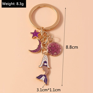 Detail view of a gold keychain with purple enamel mermaid and moon charms with dimensions