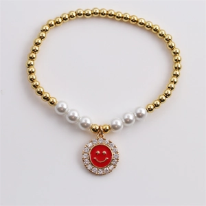 Golden beaded bracelet with white pearls and a red enamel zircon smiley face charm
