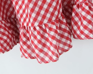 Vue détaillée du tissu vichy rouge et blanc avec un design élégant à volants