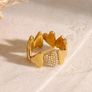 Macro detail of 18k gold plated heart ring with zircon crystal on stone surface
