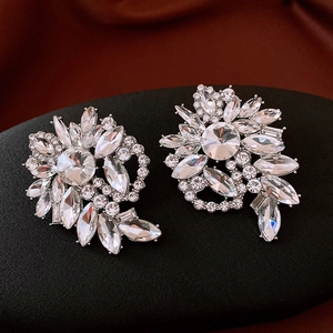 Detailed close-up of geometric floral rhinestone earrings with silver plating and crystals