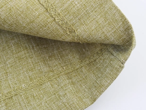 Macro detail of yellow-green linen fabric texture and high-quality edge stitching