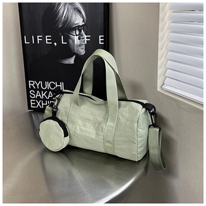 Detail of sage green cylinder fitness bag with a matching coin purse and adjustable straps