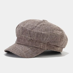 Detailed side view showing brown plaid texture on a vintage British style octagonal cap