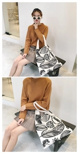 Dettaglio di una borsa tote in tela chic con stampe botaniche nere su base bianca.
