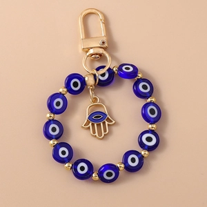 Detailed view of evil eye beads and golden Hamsa hand pendant on keychain