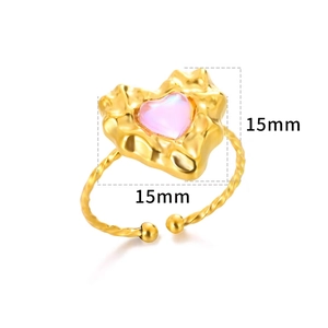 Detail of 18K gold heart ring with pink stone inlay and twisted rope band texture